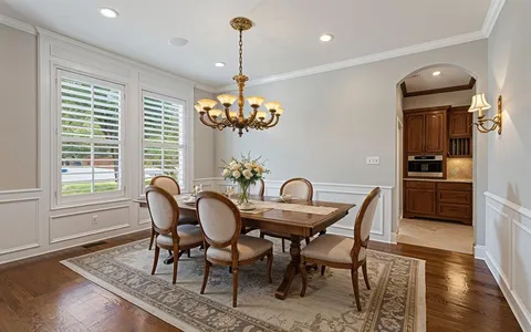 a view of a dining room with furniture a chandelier and wooden floor