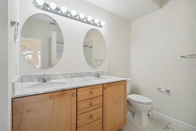 683 Main Street, Unit 22 Hackensack, NJ 07601 - Photo 12 of 15 a bathroom with a granite countertop toilet sink and mirror