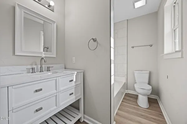 a bathroom with a toilet a sink a vanity and mirror