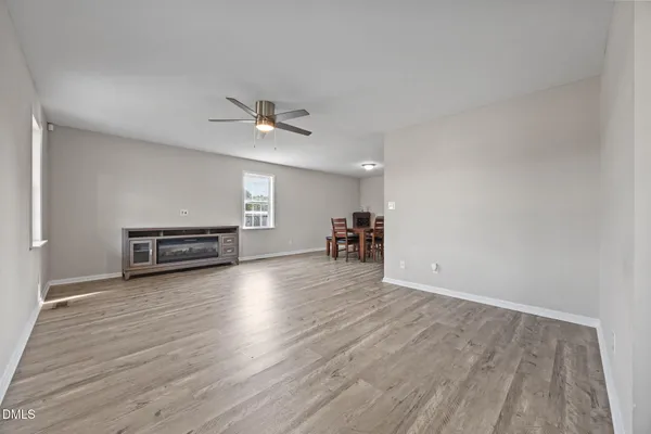 a view of a livingroom with wooden floor and a ceiling fan