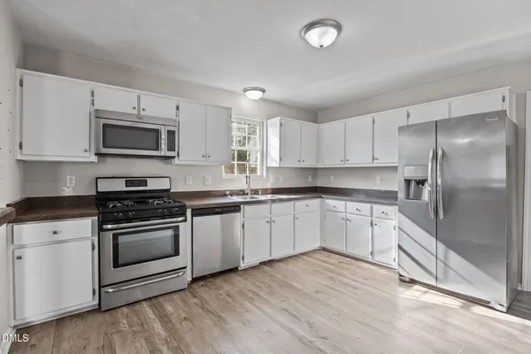 a kitchen with stainless steel appliances granite countertop a stove a sink and a microwave