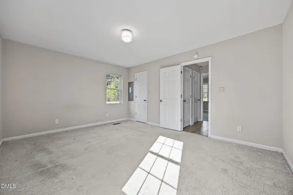 an empty room with windows and closet