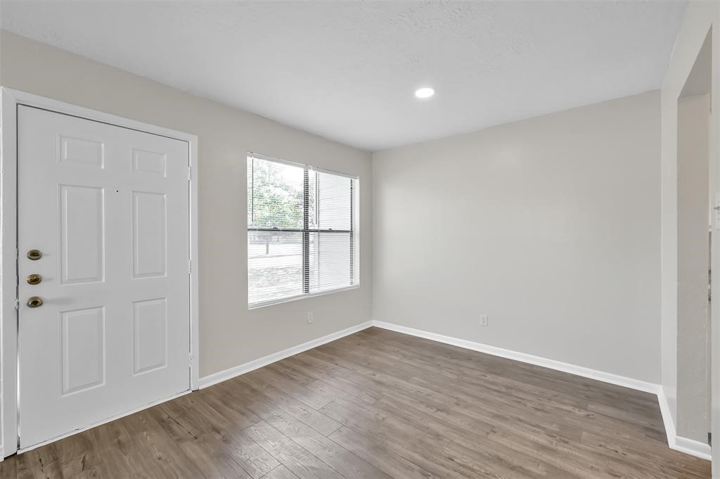 900 Holly Drive, Unit 13 Conroe, TX 77301 - Photo 6 of 12 an empty room with wooden floor and windows