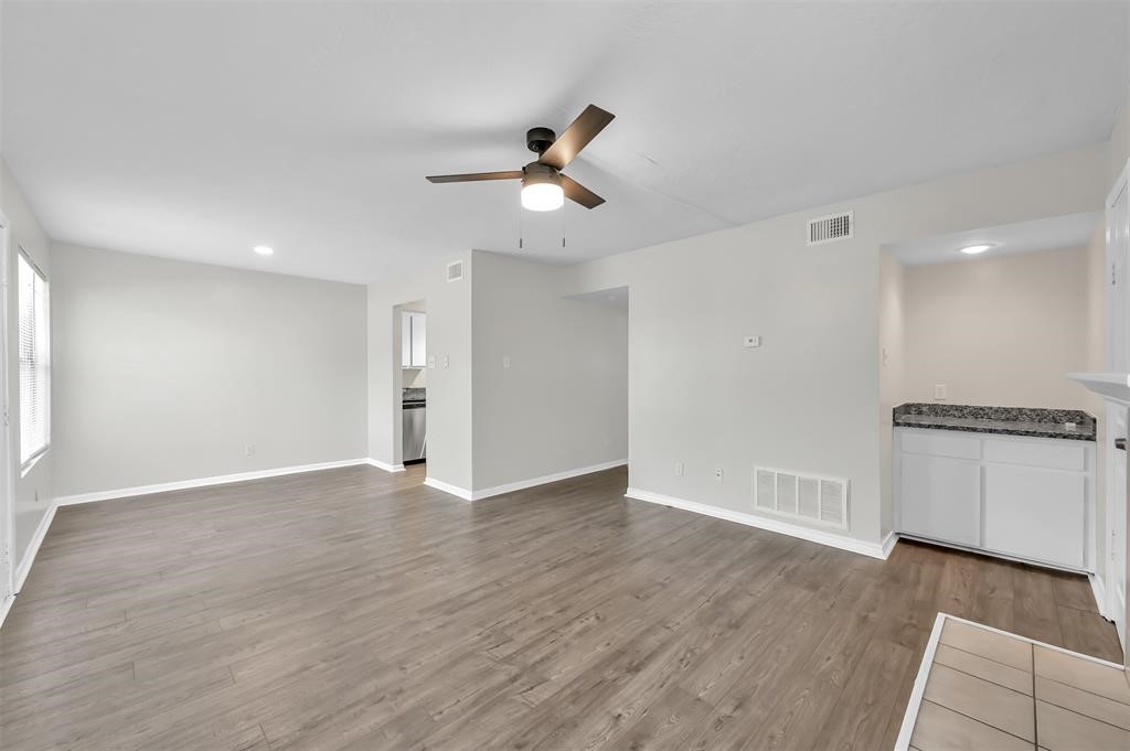 900 Holly Drive, Unit 13 Conroe, TX 77301 - Photo 7 of 12 wooden floor in an empty room with a window