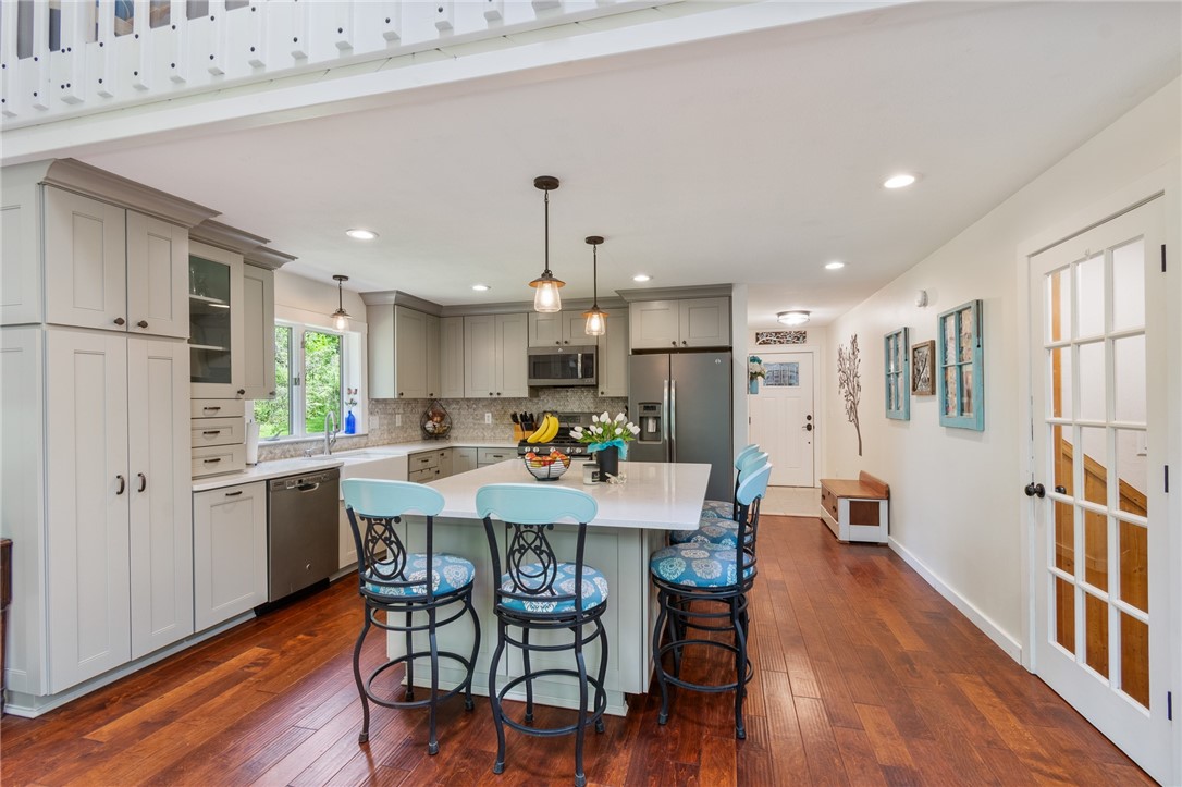 7733 East Port Bay Road Wolcott, NY 14590 - Photo 49 of 49 This OPEN FLOOR PLAN kitchen/dining area has tough BIRCH hardwood flooring - solid surface counters, ample cupboard and counter space too!