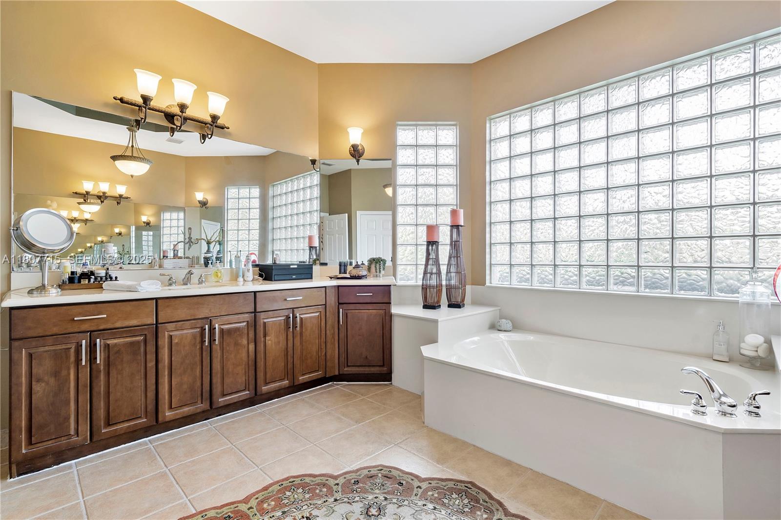 14933 Southwest 33rd Street Davie, FL 33331 - Photo 41 of 88 a spacious bathroom with a double vanity sink large mirror and a bathtub