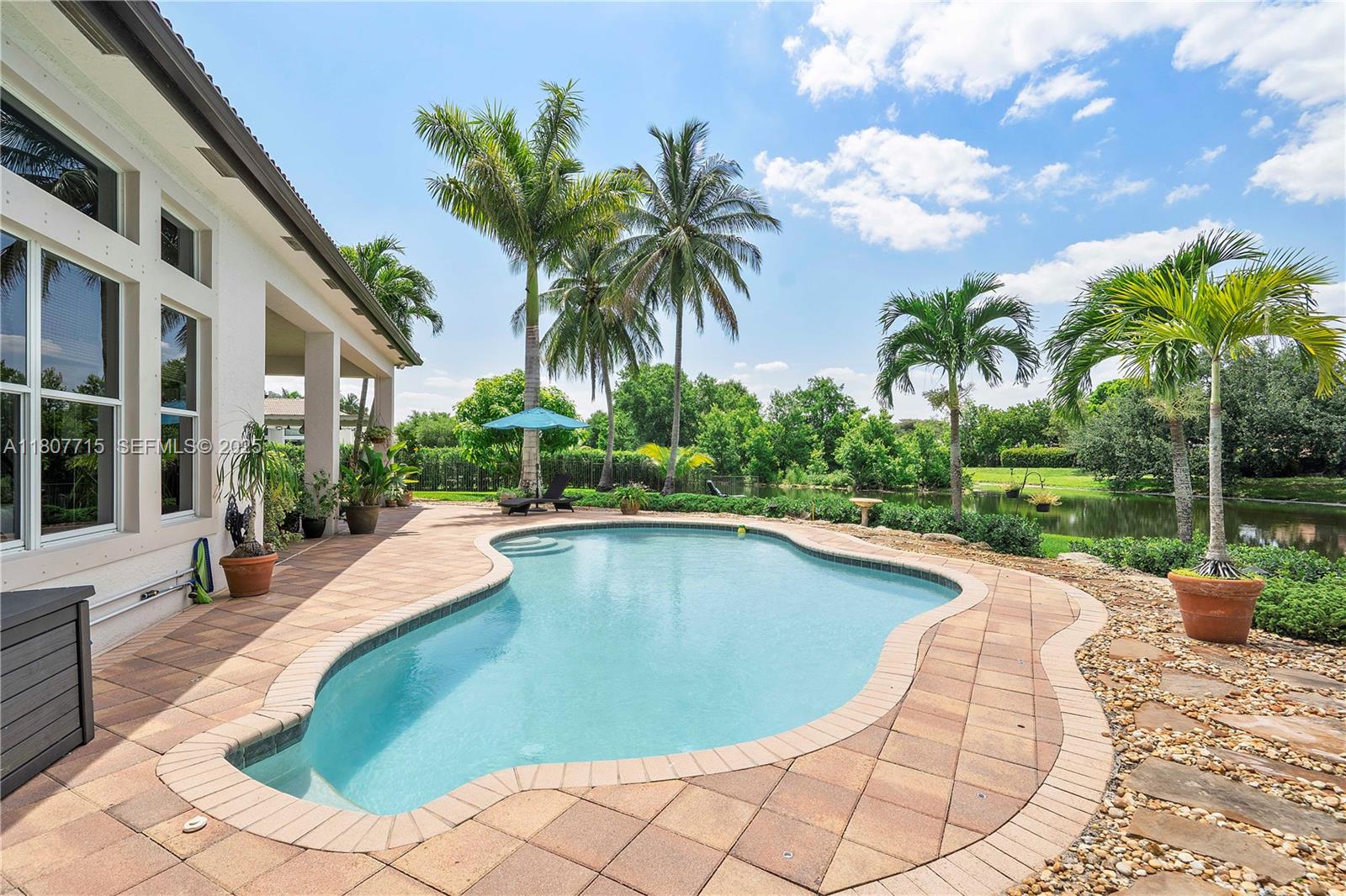 14933 Southwest 33rd Street Davie, FL 33331 - Photo 56 of 88 a view of a swimming pool with a lounge chair and palm trees