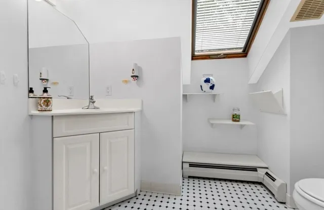 a bathroom with a sink a toilet and a mirror
