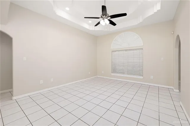 an empty room with windows and ceiling fan