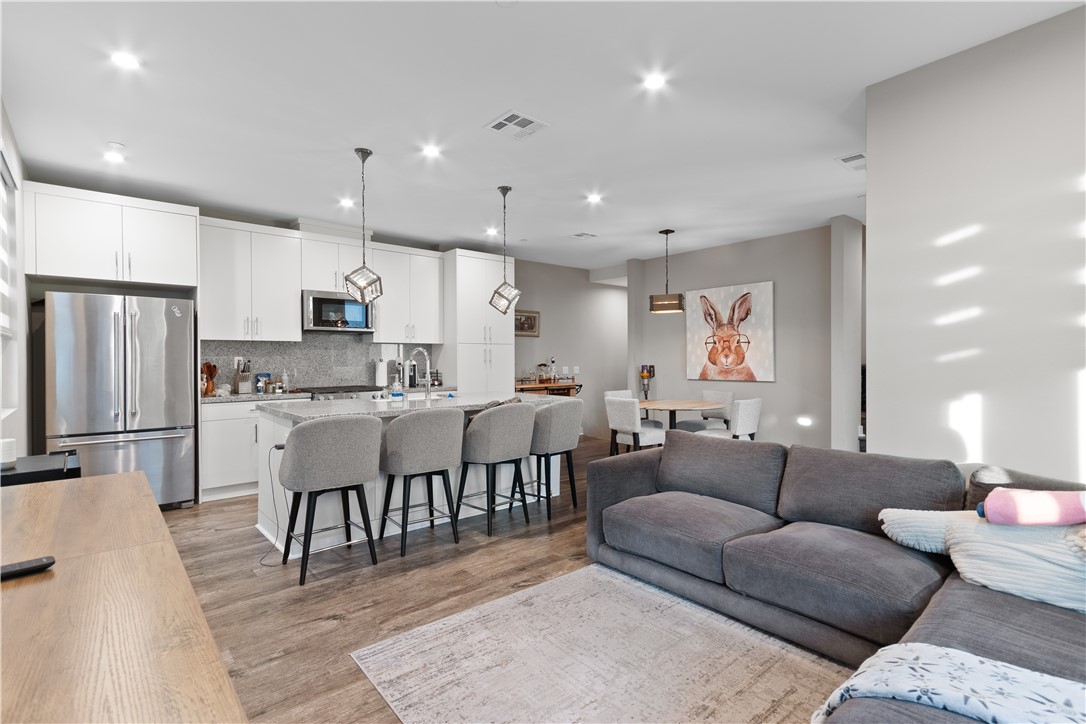 1215 West Bushell Street Anaheim, CA 92805 - Photo 1 of 24 a living room kitchen with a dining table wooden floor and stainless steel appliances
