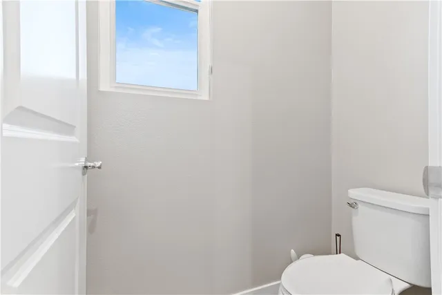 a white toilet sitting next to a white cabinet