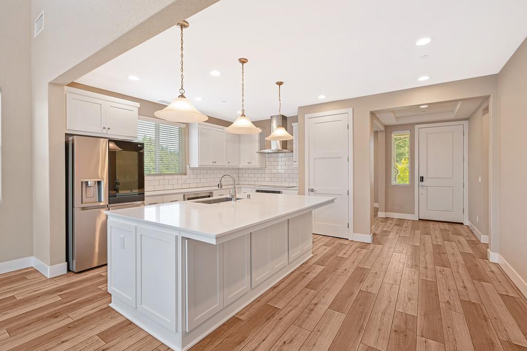 504 Chase Court Colfax, CA 95713 - Photo 33 of 94 a large white kitchen with a sink a refrigerator and wooden floor