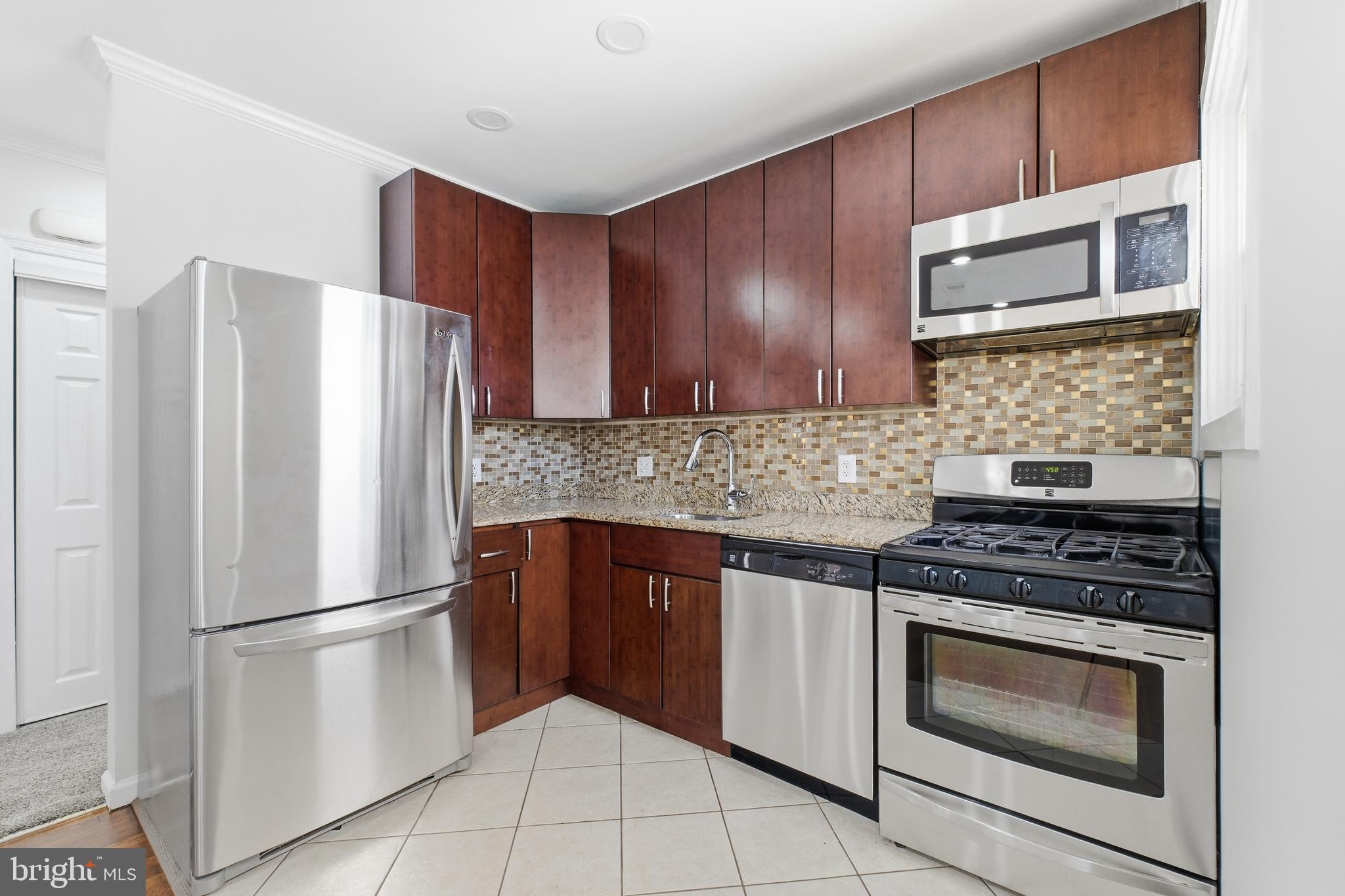 2712 6th Street Northeast Washington, DC 20017 - Photo 4 of 24 a kitchen with stainless steel appliances granite countertop a refrigerator stove and cabinets