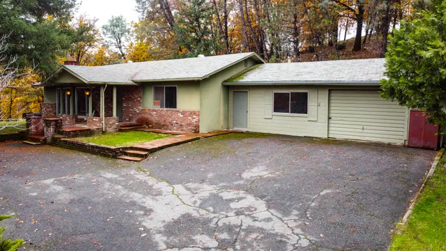 a view of a house with backyard and trees