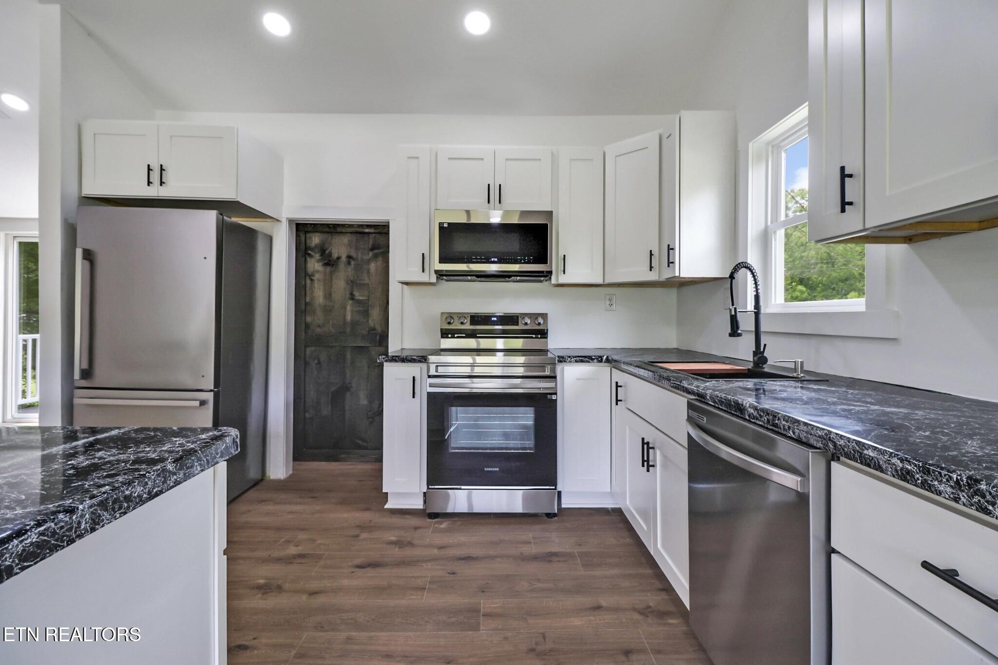 1095 Franklin Road Jamestown, TN 38556 - Photo 17 of 31 a kitchen with stainless steel appliances granite countertop a stove top oven a sink and a refrigerator