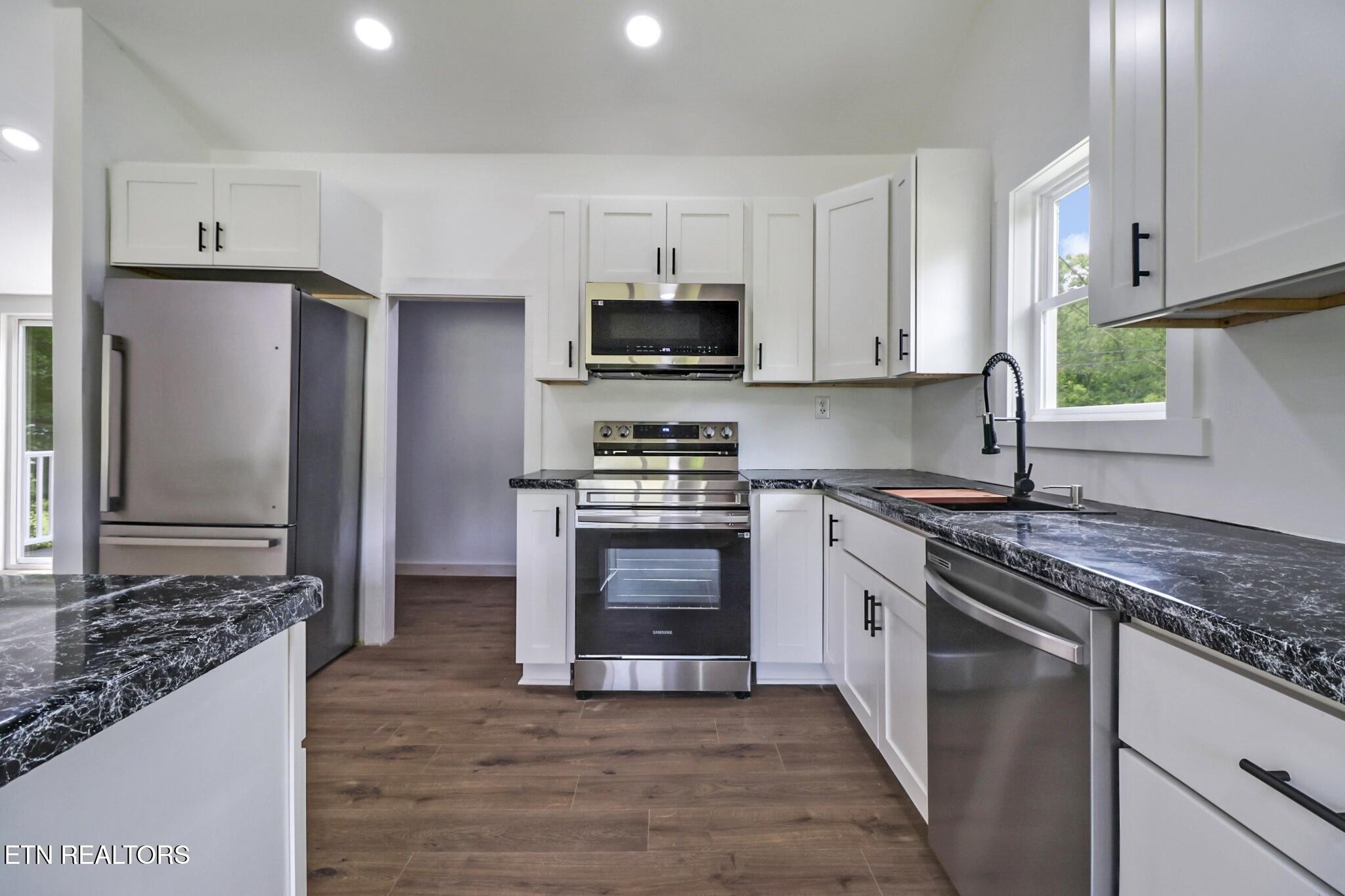 1095 Franklin Road Jamestown, TN 38556 - Photo 18 of 31 a kitchen with stainless steel appliances granite countertop a stove top oven a sink and a refrigerator