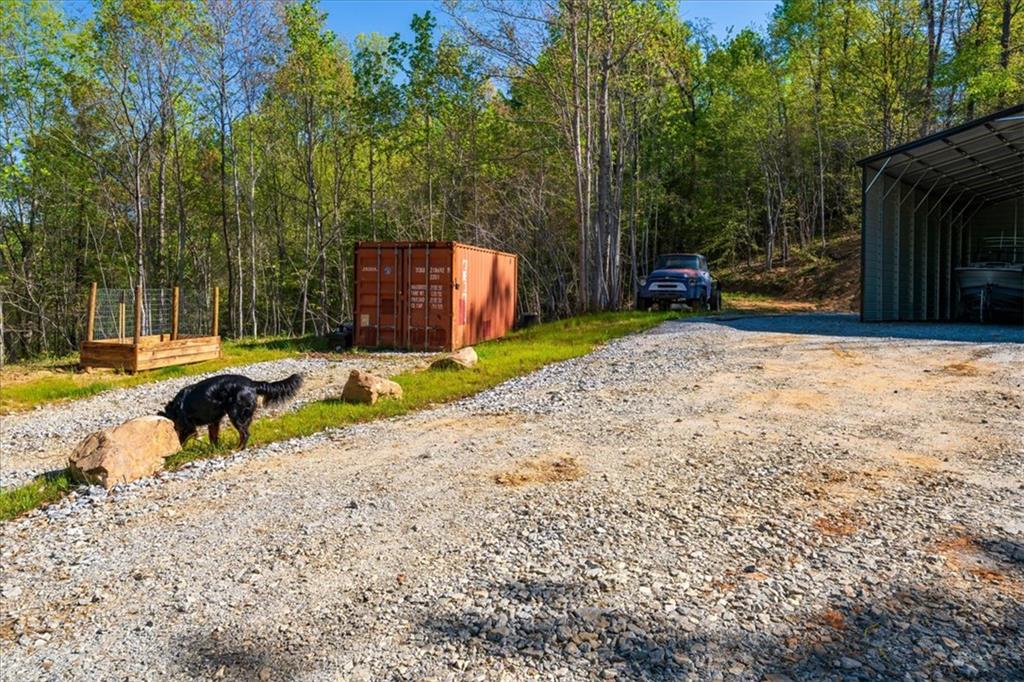 280 Dan Ross Road Six Mile, SC 29682 - Photo 3 of 18 A well-maintained gravel driveway leads to ample open-air storage and a dedicated garden space.
