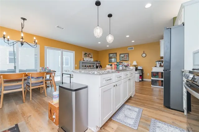 a large kitchen with granite countertop lots of counter space dining table and stainless steel appliances