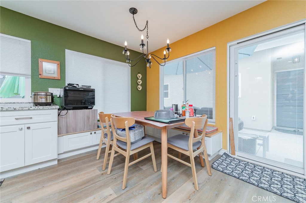 23 Country Ridge Road Phillips Ranch, CA 91766 - Photo 13 of 45 a dining room with wooden floor a chandelier a wooden table and chairs