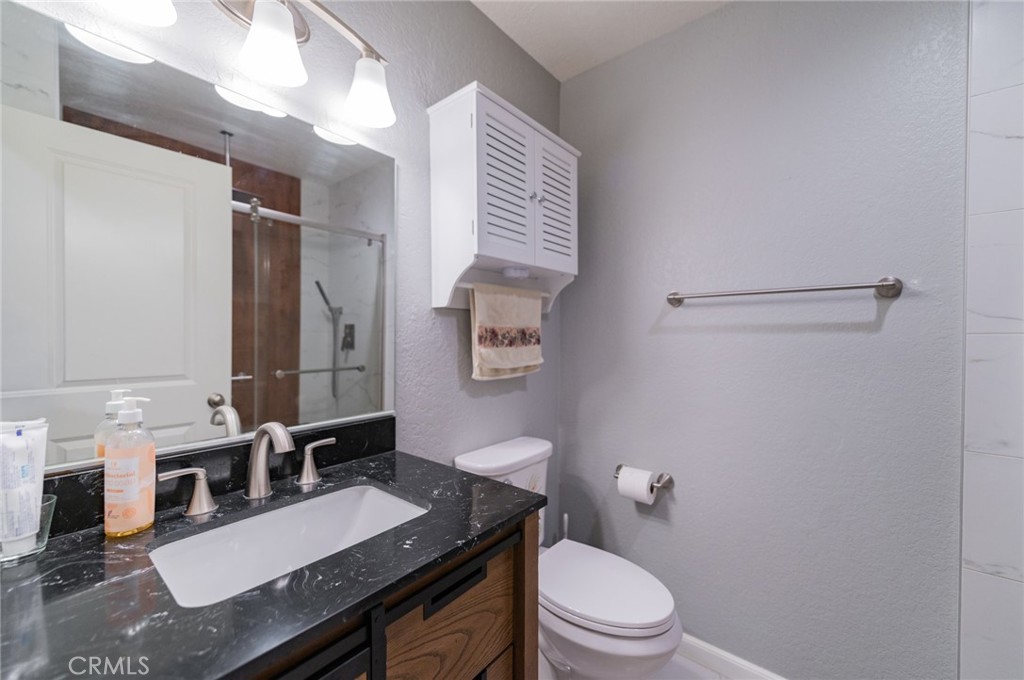 23 Country Ridge Road Phillips Ranch, CA 91766 - Photo 24 of 45 a bathroom with a granite countertop sink a toilet a mirror and shower