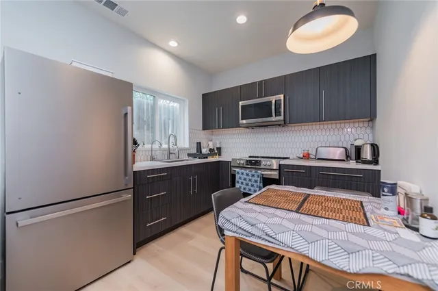 a kitchen with a refrigerator a stove top oven a sink dishwasher and wooden cabinets