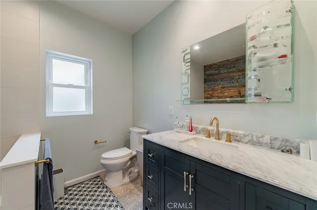 a bathroom with a sink a toilet a mirror and shower curtain