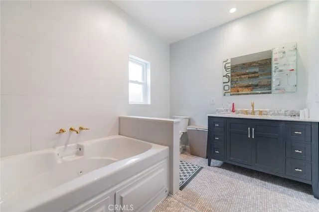 a bathroom with a tub sink and mirror