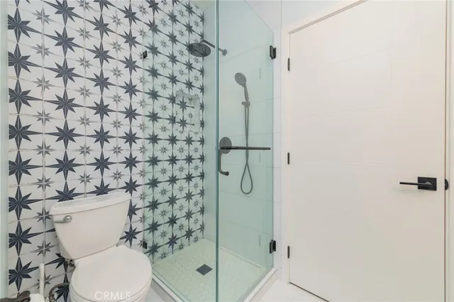 a white toilet sitting next to a shower