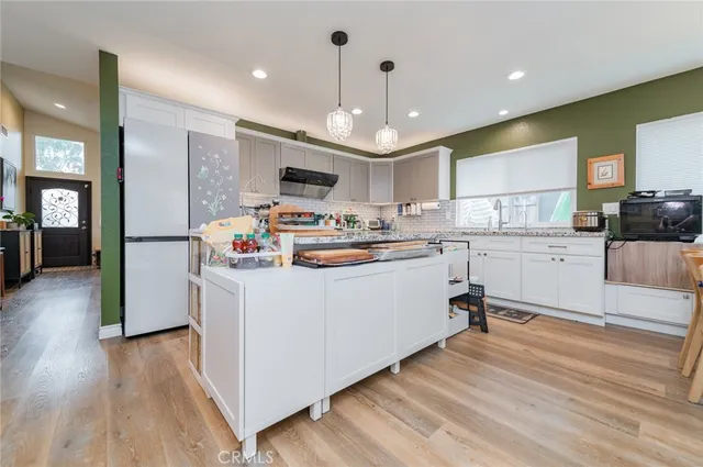 a kitchen with kitchen island stainless steel appliances a stove cabinets a sink a stove and a refrigerator