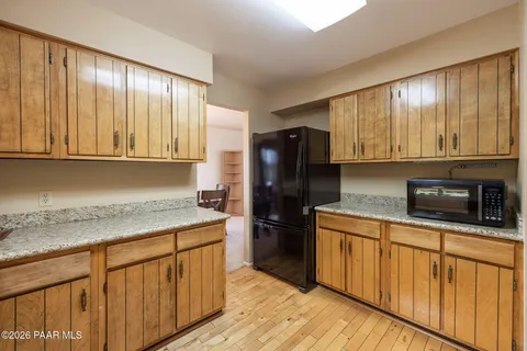 a kitchen with stainless steel appliances granite countertop wooden cabinets a stove top oven a sink and dishwasher with wooden floor