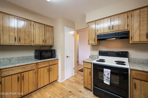 a kitchen with granite countertop wooden cabinets and stainless steel appliances