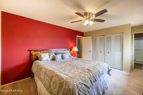a bedroom with a bed and a ceiling fan