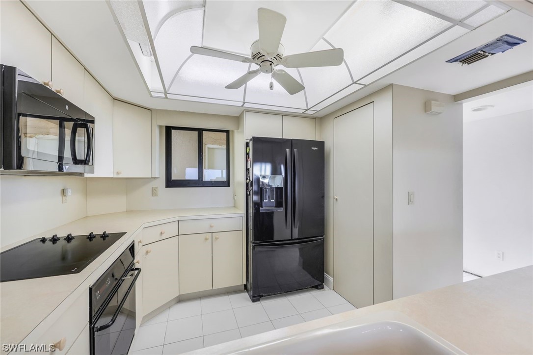 15021 Punta Rassa Road, Unit 504 Fort Myers, FL 33908 - Photo 11 of 24 a kitchen with a refrigerator and a sink