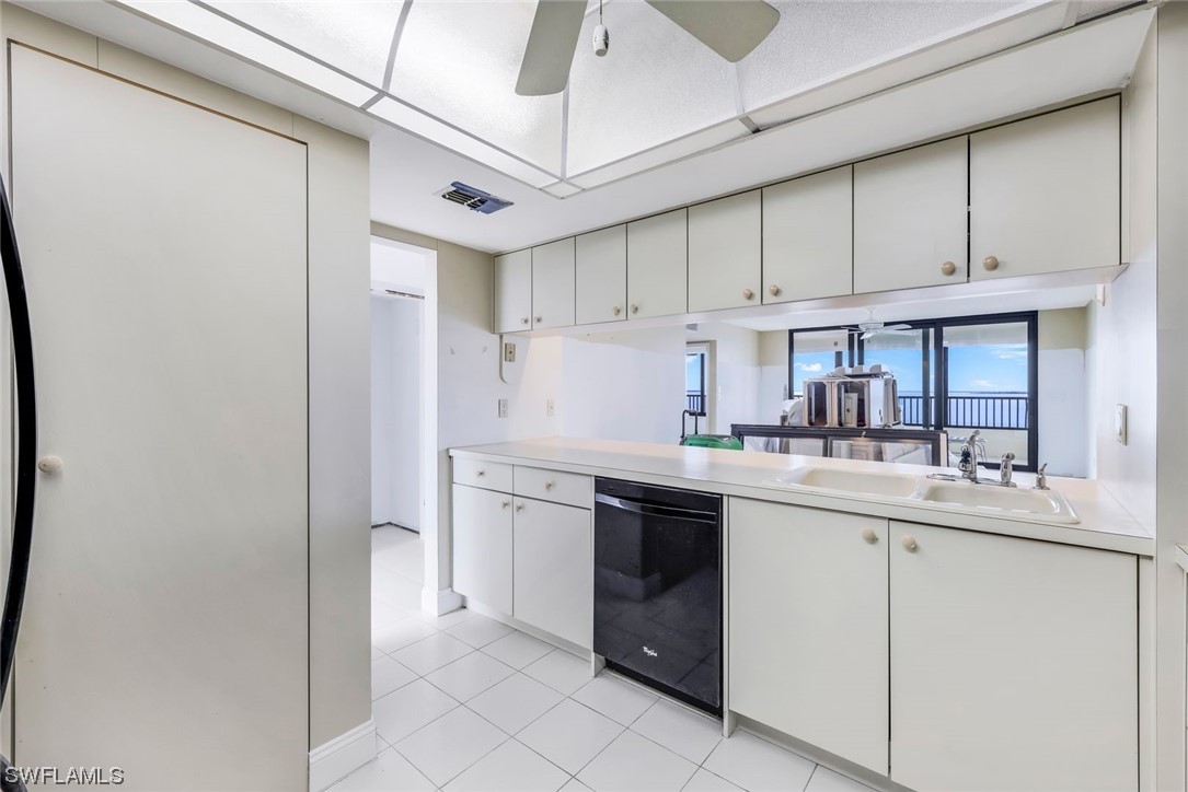 15021 Punta Rassa Road, Unit 504 Fort Myers, FL 33908 - Photo 13 of 24 a kitchen with kitchen island granite countertop a sink stainless steel appliances and cabinets