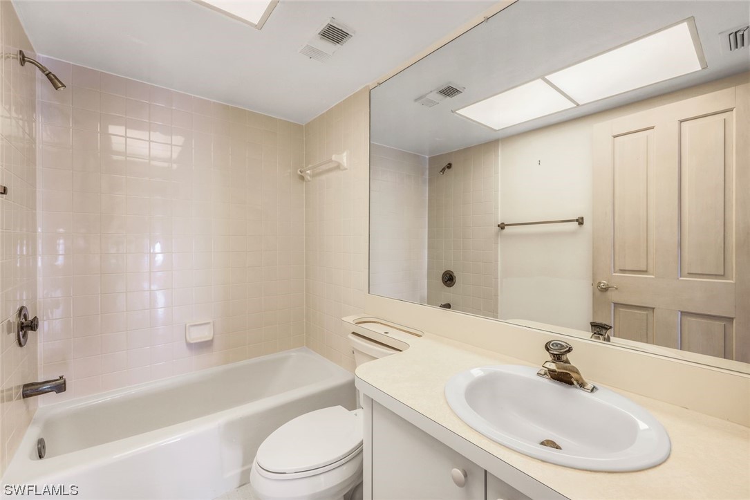 15021 Punta Rassa Road, Unit 504 Fort Myers, FL 33908 - Photo 19 of 24 a bathroom with a bathtub shower sink vanity mirror and toilet