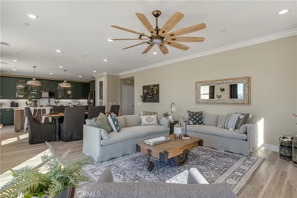 a kitchen with a sink stainless steel appliances a counter space and living room view