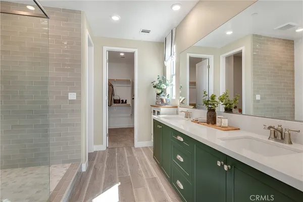 a spacious bedroom with a bed a chandelier and a large window