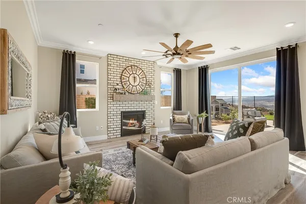 a living room with furniture kitchen view and a chandelier