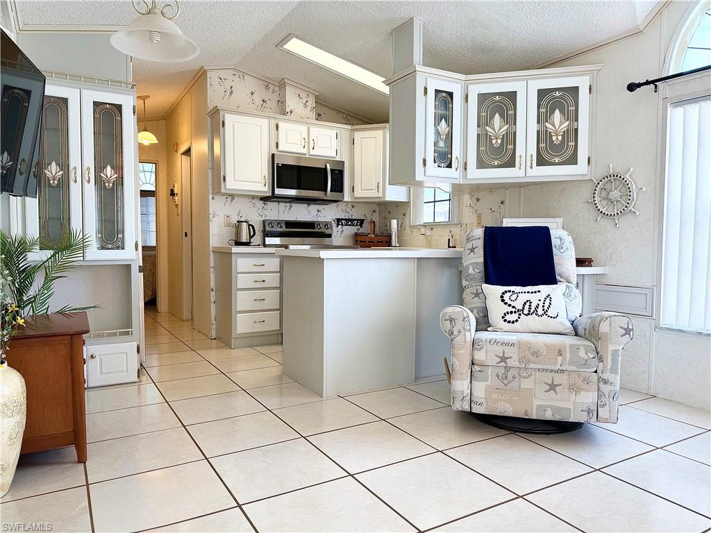233 Cattleya Refuge, Unit 233 Naples, FL 34114 - Photo 13 of 48 a kitchen with stainless steel appliances a stove a sink and a microwave