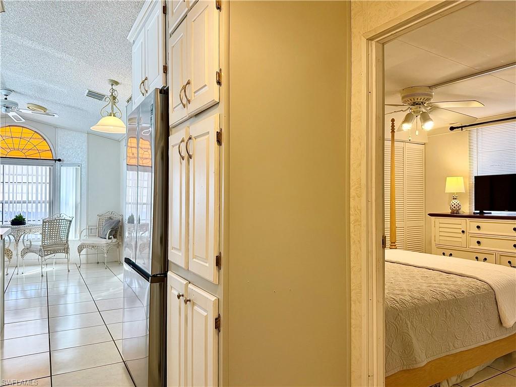 233 Cattleya Refuge, Unit 233 Naples, FL 34114 - Photo 19 of 48 a view of a bedroom with a bed and a tv