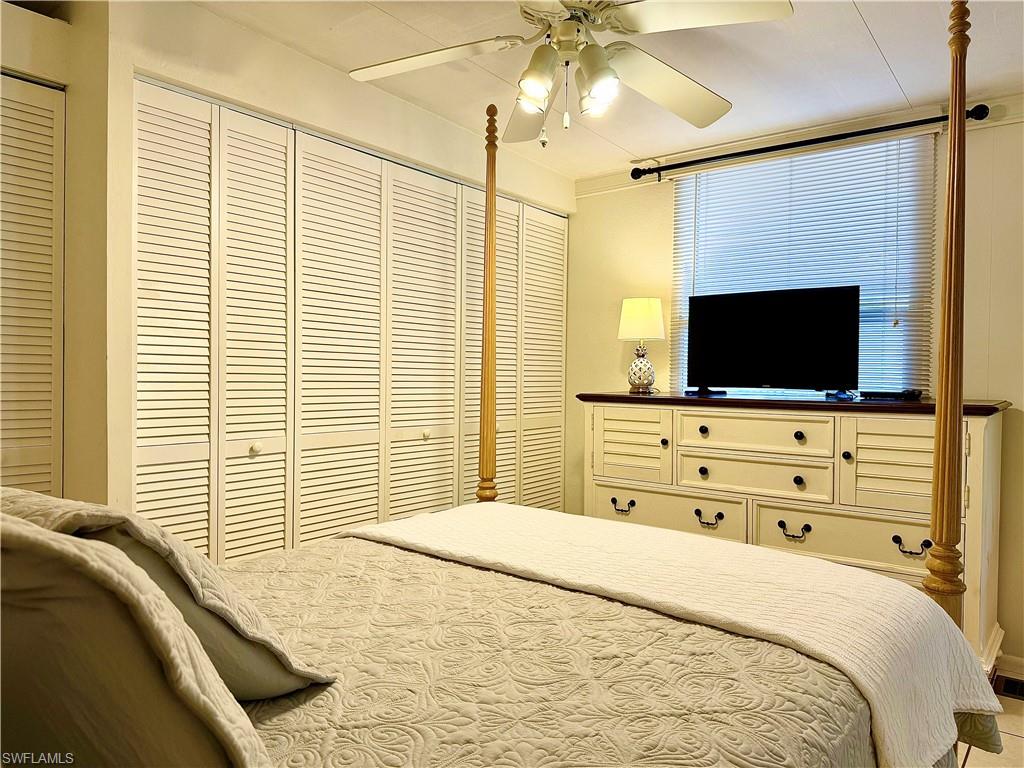 233 Cattleya Refuge, Unit 233 Naples, FL 34114 - Photo 20 of 48 a bedroom with a bed and a flat screen tv