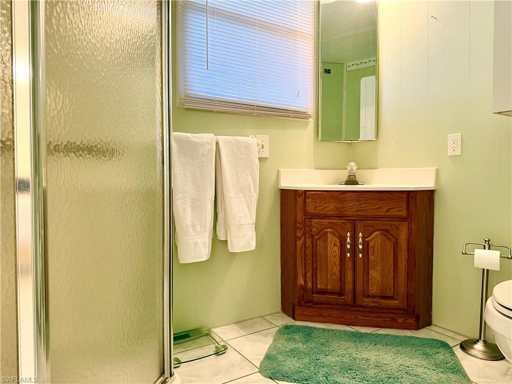 233 Cattleya Refuge, Unit 233 Naples, FL 34114 - Photo 23 of 48 a bathroom with a granite countertop sink and a mirror