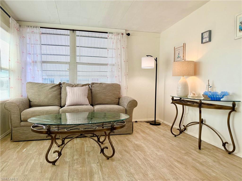 233 Cattleya Refuge, Unit 233 Naples, FL 34114 - Photo 10 of 48 a living room with furniture and a wooden floor