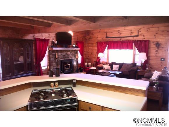 2406 Hemphill Road Waynesville, NC 28785 - Photo 15 of 19 a kitchen with stainless steel appliances kitchen island granite countertop a sink dishwasher and a fireplace with wooden floor