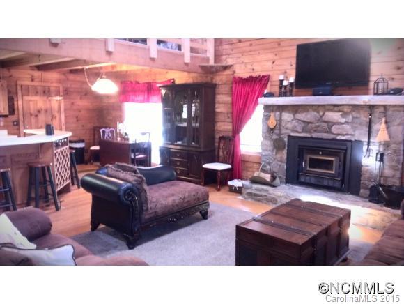 2406 Hemphill Road Waynesville, NC 28785 - Photo 8 of 19 a living room with furniture a fireplace and a flat screen tv