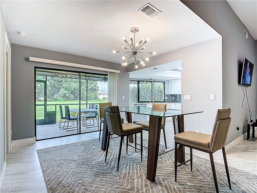 183 Round Key Circle, Unit D4 Naples, FL 34112 - Photo 21 of 49 a dining room with furniture a chandelier and wooden floor