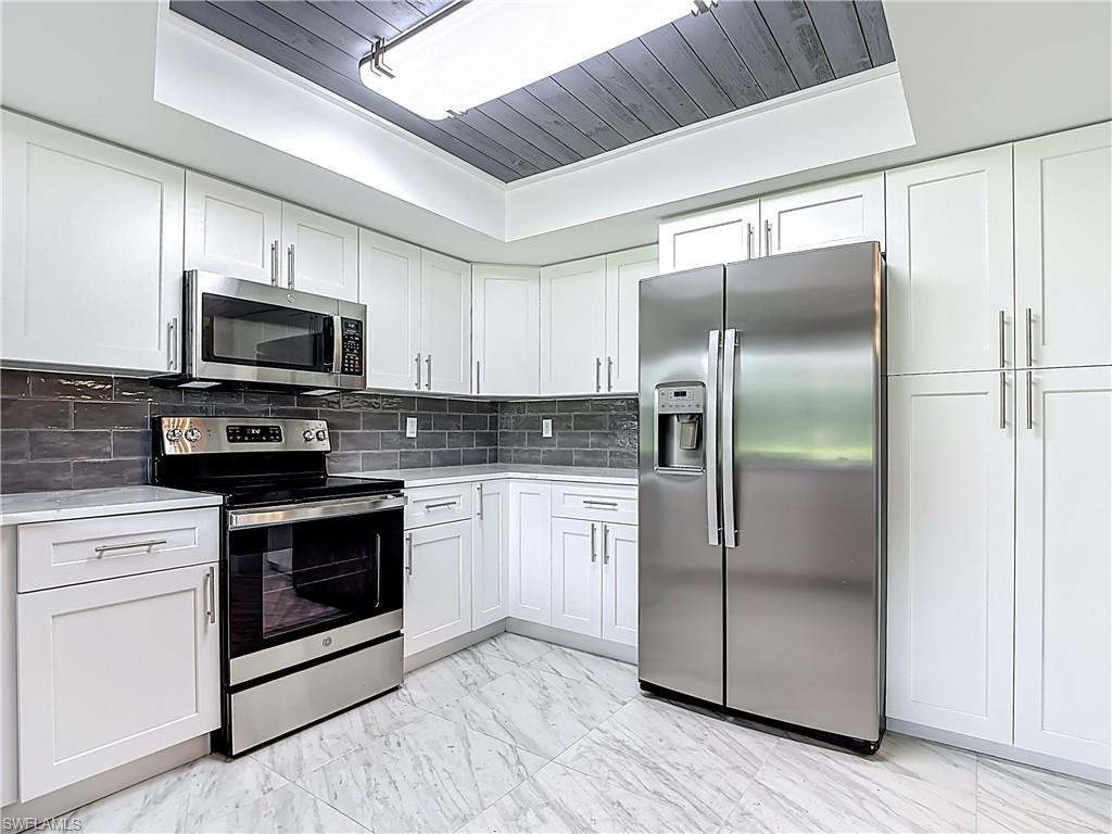 183 Round Key Circle, Unit D4 Naples, FL 34112 - Photo 22 of 49 a kitchen with a refrigerator stove and microwave