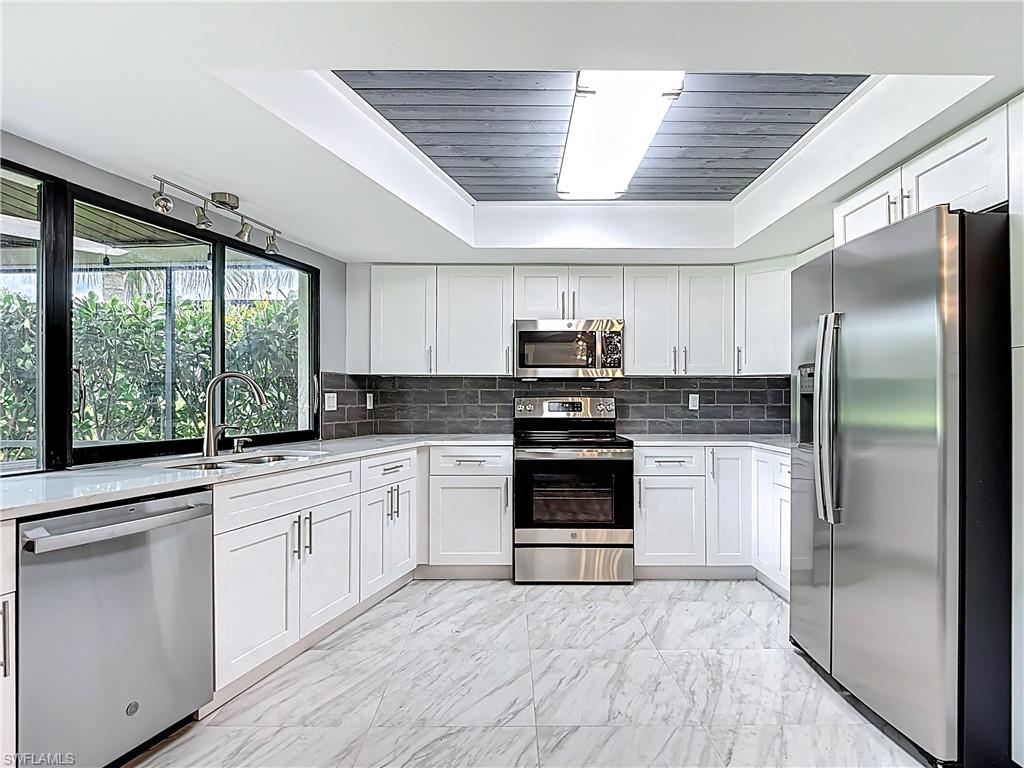 183 Round Key Circle, Unit D4 Naples, FL 34112 - Photo 23 of 49 a kitchen with stainless steel appliances granite countertop a refrigerator and a stove top oven