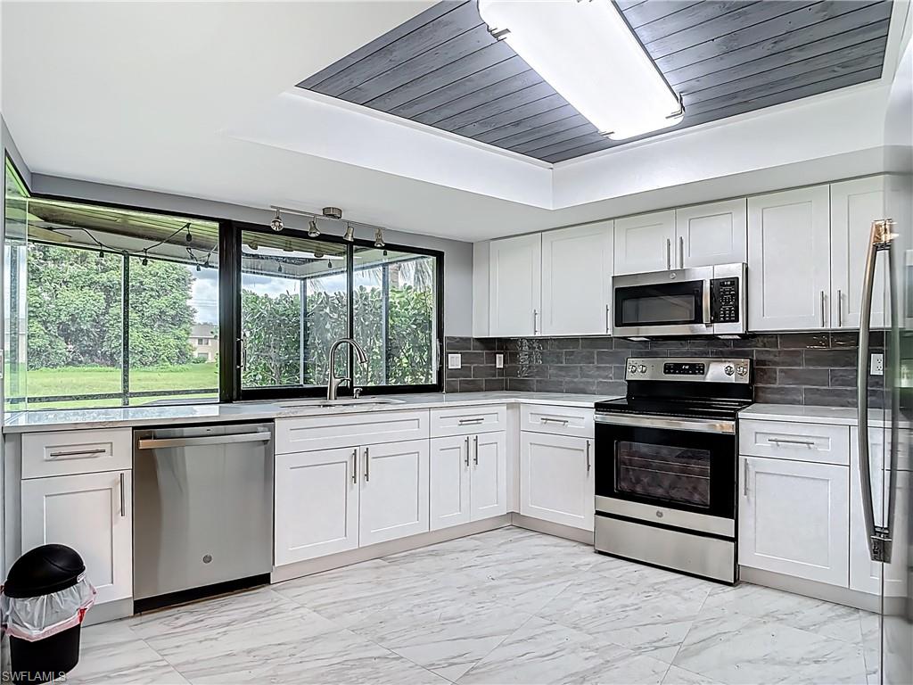183 Round Key Circle, Unit D4 Naples, FL 34112 - Photo 24 of 49 a kitchen with a stove a sink and a microwave