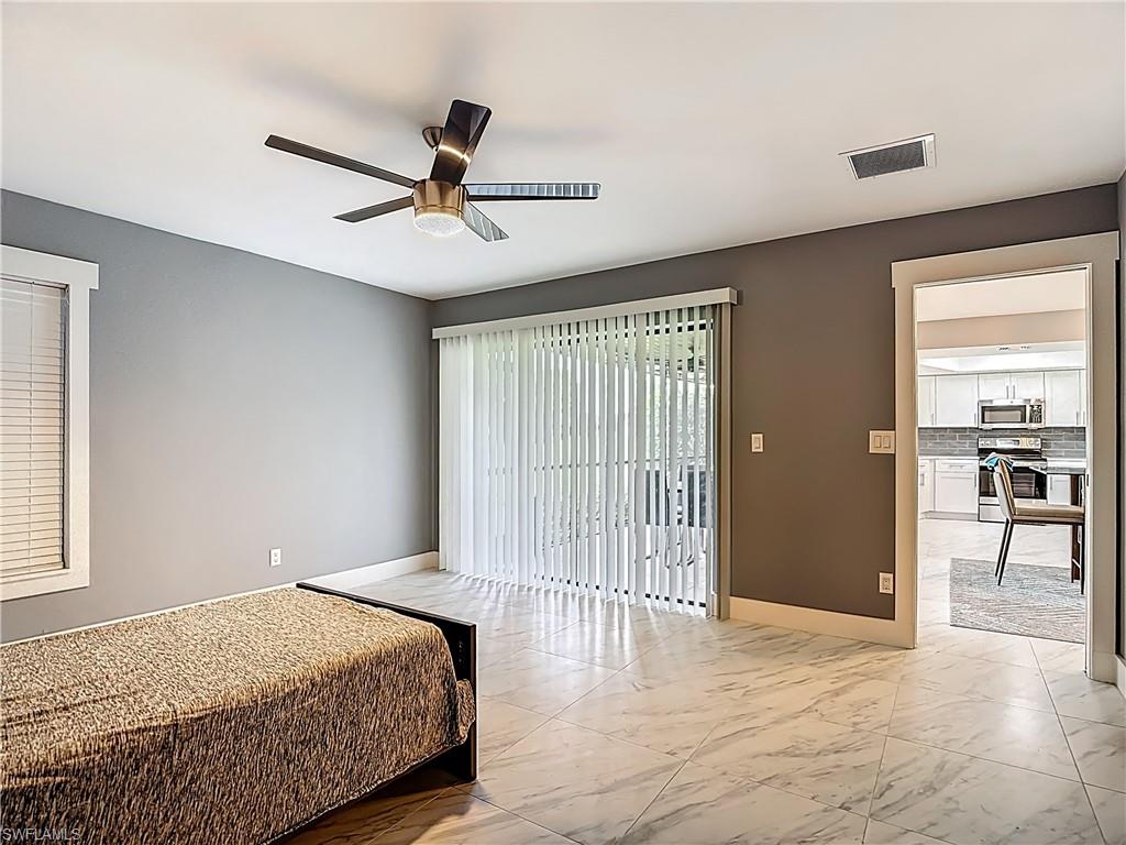 183 Round Key Circle, Unit D4 Naples, FL 34112 - Photo 31 of 49 a bedroom with a bed and a chandelier